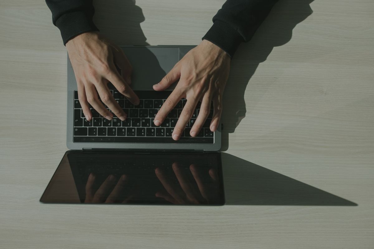 Close-up of hands typing on a laptop keyboard