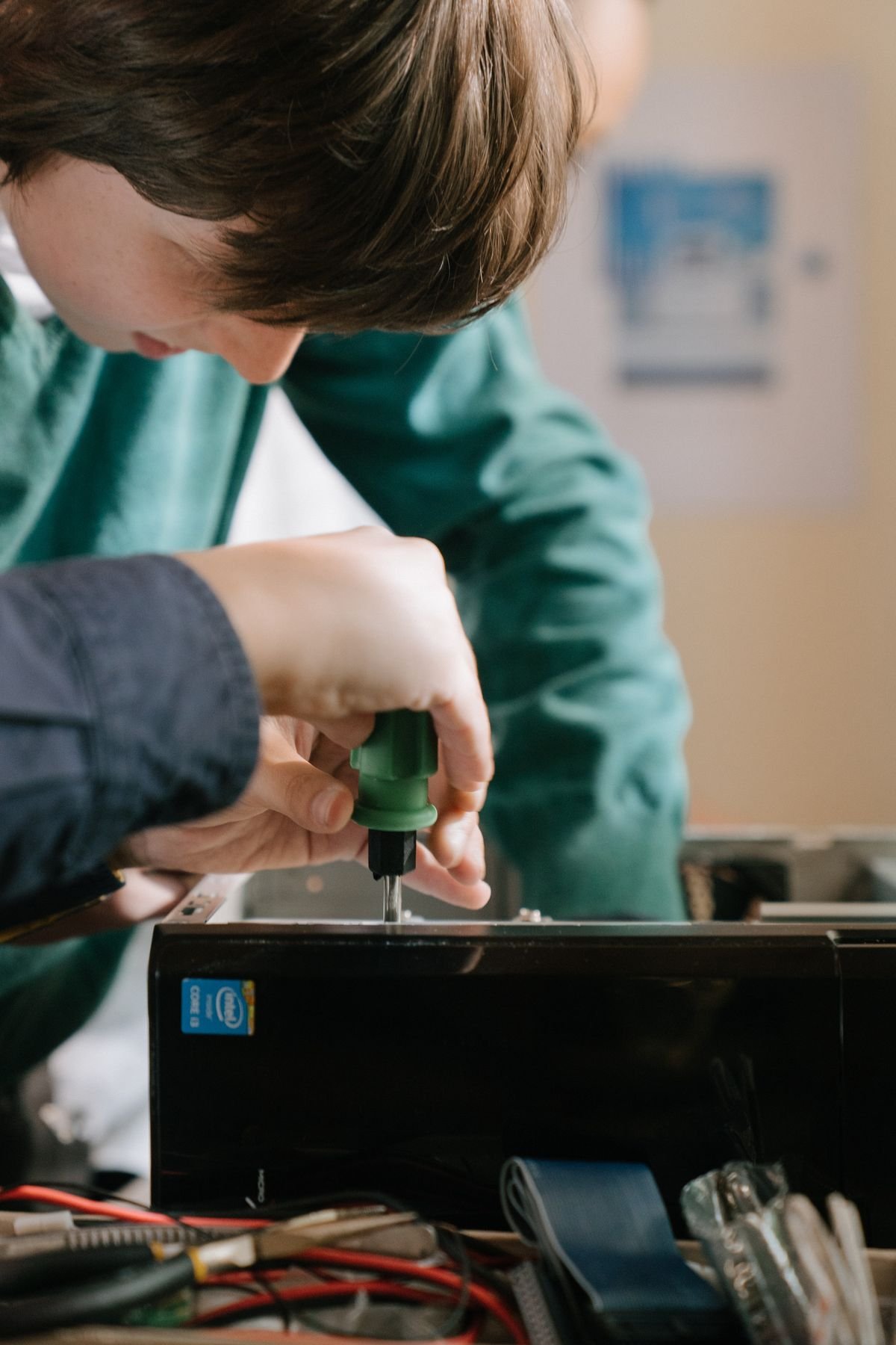 Close-up of hands repairing a computer with a screwdriver