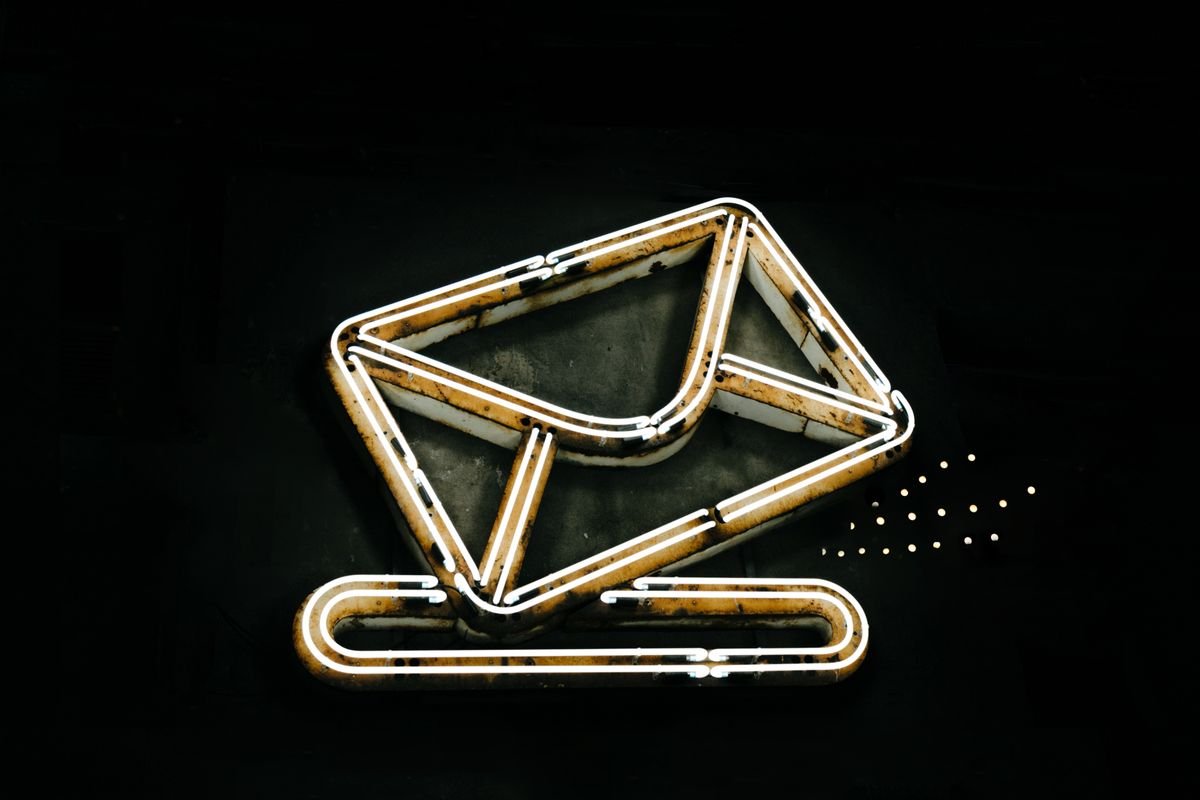 A glowing neon envelope symbol against a black background